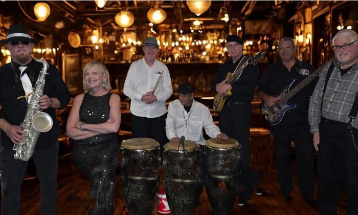 The seven member band, RosyBlue and the Dreamers, in a dark bar with old-fashioned lights