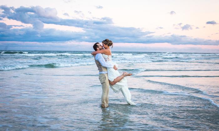 A couple celebrate in the surf after their beach wedding in St. Augustine. Photo by Sun and Sea Weddings.
