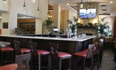 The L-shaped bar at the DoubleTree by Hilton, with red seats and dark wood chairs