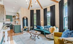 Green curtains, glass accents, and wood floors make this living room cozy