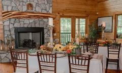 Tables arranged and decorated for an event near the stone fireplace at the Farmhouse at Ancient City Farmstead