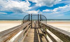 The private gate to the beach on a boardwalk from a condo community
