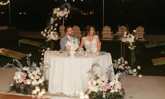A couple at their wedding reception laughing with guests