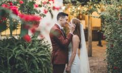 The bride and groom sharing a private moment near a flowering tree