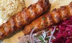 A kebab with a side of rice and veggies