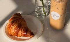 A croissant and iced coffee bottle
