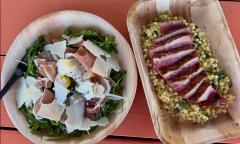 An arugula salad and tuna over couscous dish