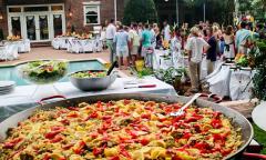 A large dish of paella at an outdoor party.