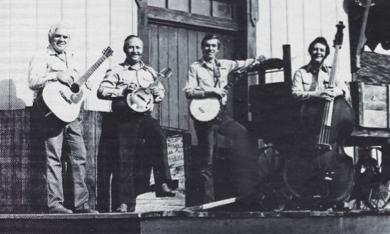 Four members of the Shady Grove Ramblers in the 1960s. They pose shoulder to shoulder with their musical instruments