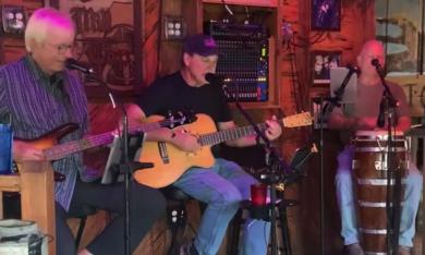 The JC Hatfield Trio, on bass, guitar, and congas, playing a gig at the Mill Top Tavern