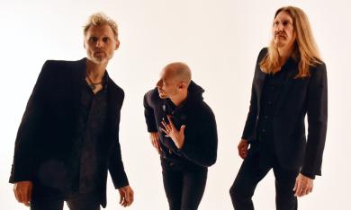 Members of the Wood Brothers band smile and pose in black clothing.