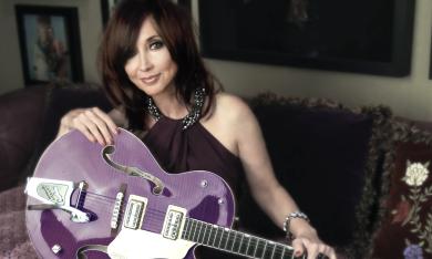 Pam Tillis poses with her purple guitar. 