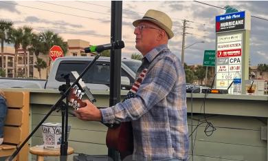 Joe Targove, local musician, performing outside at Hurricane Grill