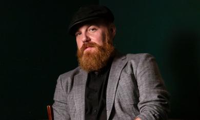 Marc Broussard poses in front of a black background. 