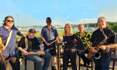 Six piece band Fran Pitre & Class act, with instruments, at the beach.