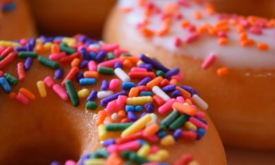 Donuts with sprinkles are positioned on the table. 