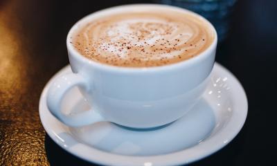 Cappuccino served in a white coffee mug. 