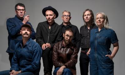 Musical duo Belle and Sebastian and their band, against a grey background