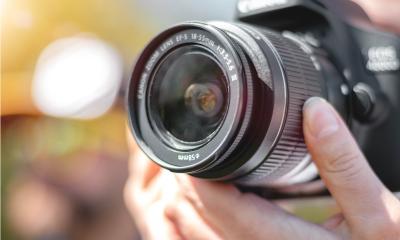 A photographer adjusts his lens to take a picture. 