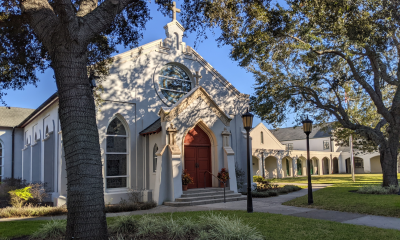 An image of the St. George Street entrance of Trinity Parish Episcopal Church in St. Augustine, Florida. A sunny day under the oaks.