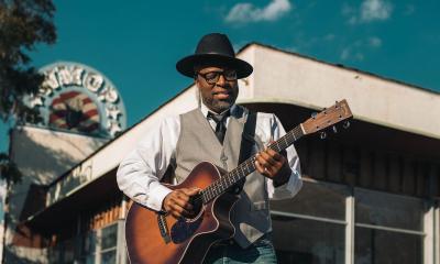 Musician Billy buchanan with guitar in front of building