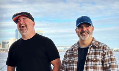 Headshot of musical duo Sparks In The Garden outside on the St. Johns River, laughing