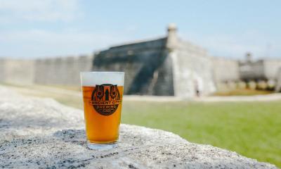 A pint of Ancient City beer on a wall in front of the fort