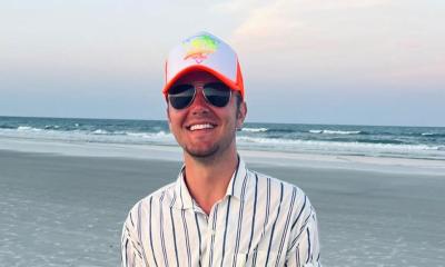 headshot of Chase Fouraker in ball cap and sunglasses, with the beach in the background