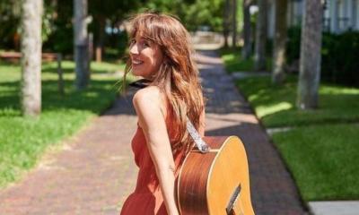 Alana DeBow walking with her guitar