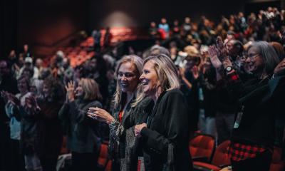 Two women standing an applauding in an audience at the St. Augustine Film Festival