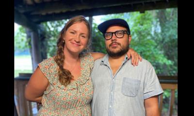Abigail and Andre Gruber standing together; she is smiling, he is stoic