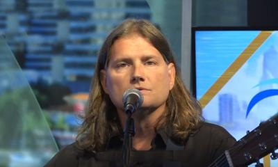 Songwriter Darran Ronan playing his guitar onstage