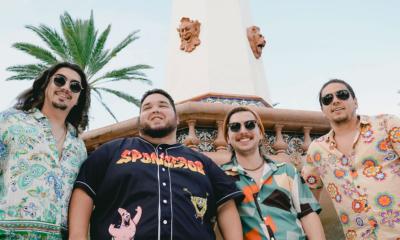 The band Dionysus standing outside under a palm tree