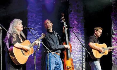 Gatorbone Trio on stage with instruments, performing.