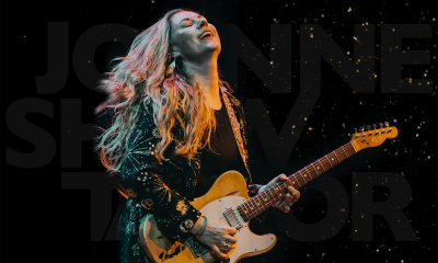 Joanne Shaw Taylor clutches her guitar while performing on stage.