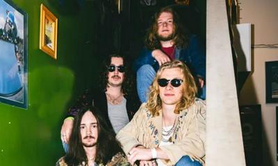 The band Red Magnolia sitting on a staircase