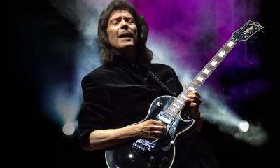 Steve Hackett strums his guitar and performs on stage.
