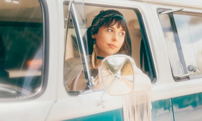 Veronica Swift cants her head and peers out of a vintage vehicle with green and white paint. 