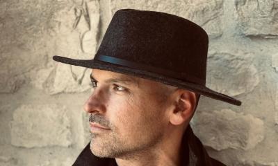 Jon Nite in a black hat, standing next to a stone wall
