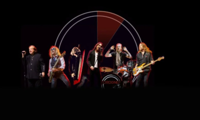 Bandmates from Foreigner pose with their guitars and drums.