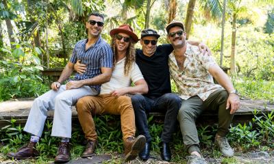 The four members of Honey Hounds sitting on a log in the forest