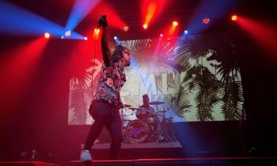 Cellus on stage with colored lights and an energetic performance