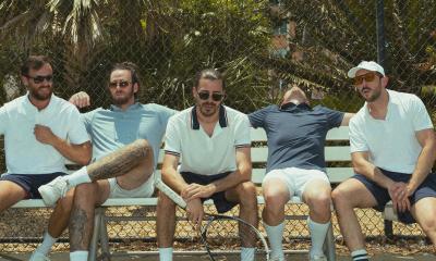 The band Ajeva sitting on a bench, in tennis clothing