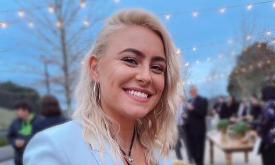 Songwriter Emma Zinck grinning, outside at dusk