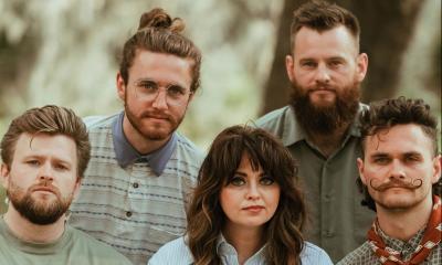 the band Dawson Hollow sitting together, with trees in the background