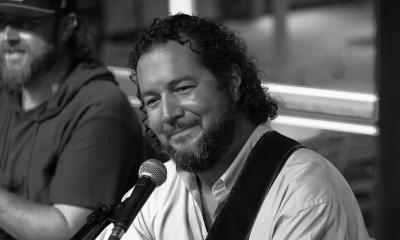 Musician John Fowler smiling on stage.