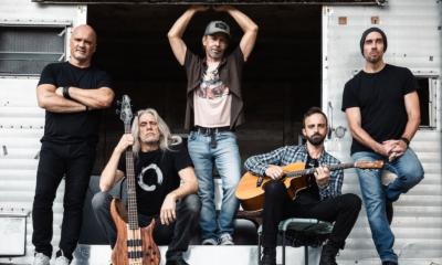 Bandmates from Given to Fly pose with their musical instruments.