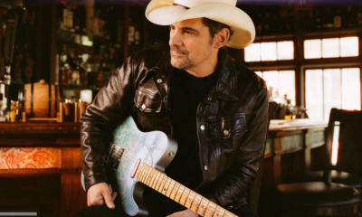 Brad Paisley poses with a white cowboy hat and matching guitar.
