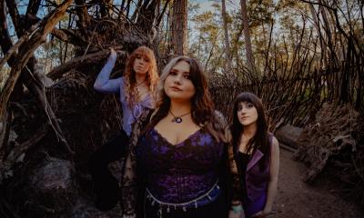 Annie Dukes, the three members standing in a spooky forest