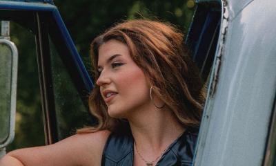 Side shot of songwriter Grace West in the door of a pickup truck